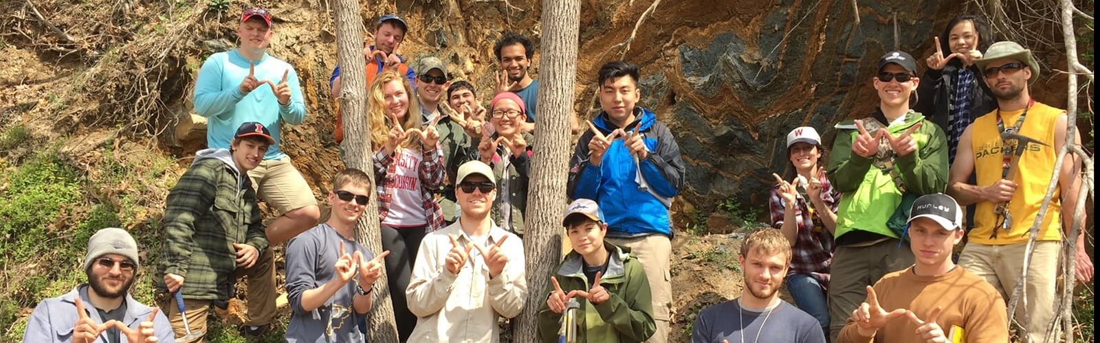 A group of Geoscience students flash the 'W' sign.